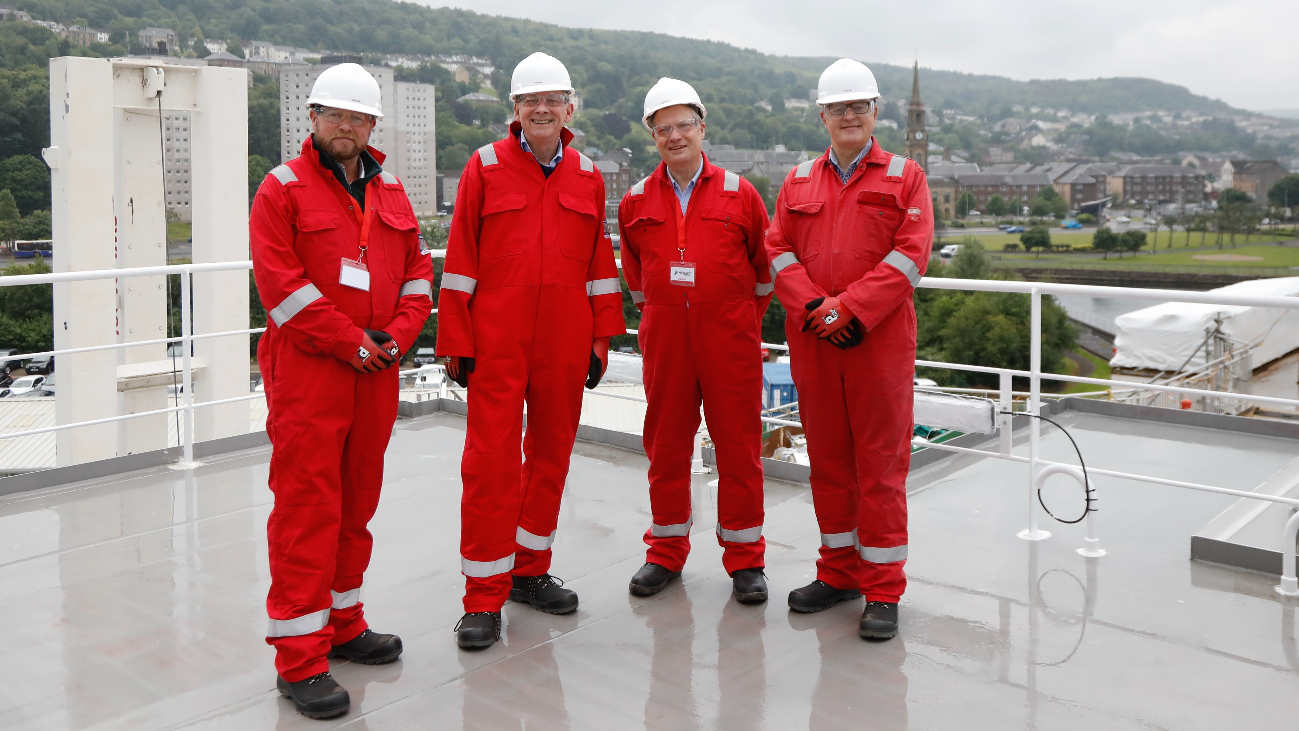 A photograph of four members of the Public Audit Committee standing on the deck of the MV Glen Rosa in Port Glasgow on 9 June 2025